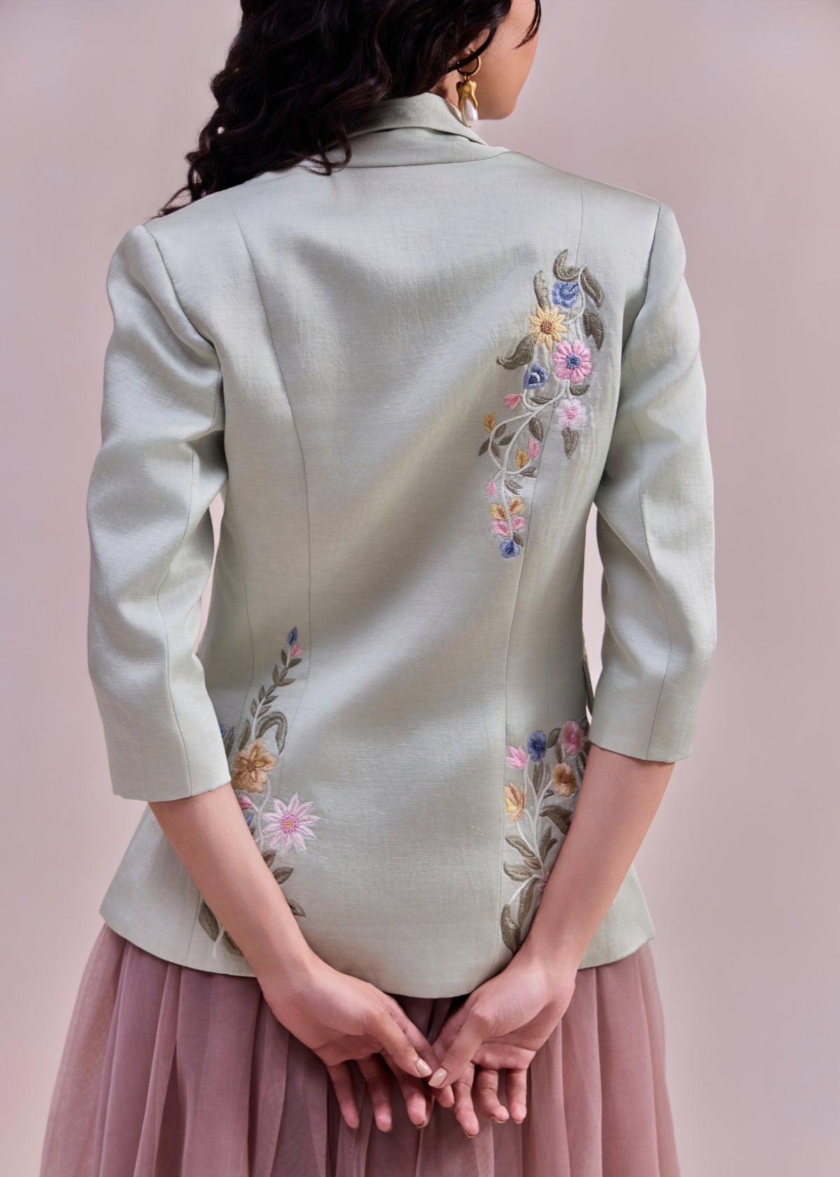 Light green blazer with floral embroidery on a pink background