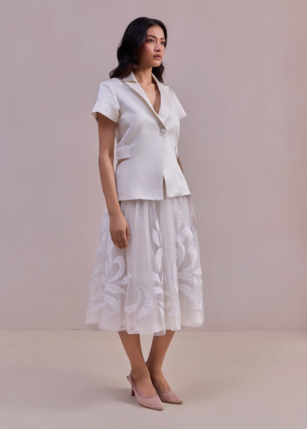 Woman wearing a white outfit with a plain background