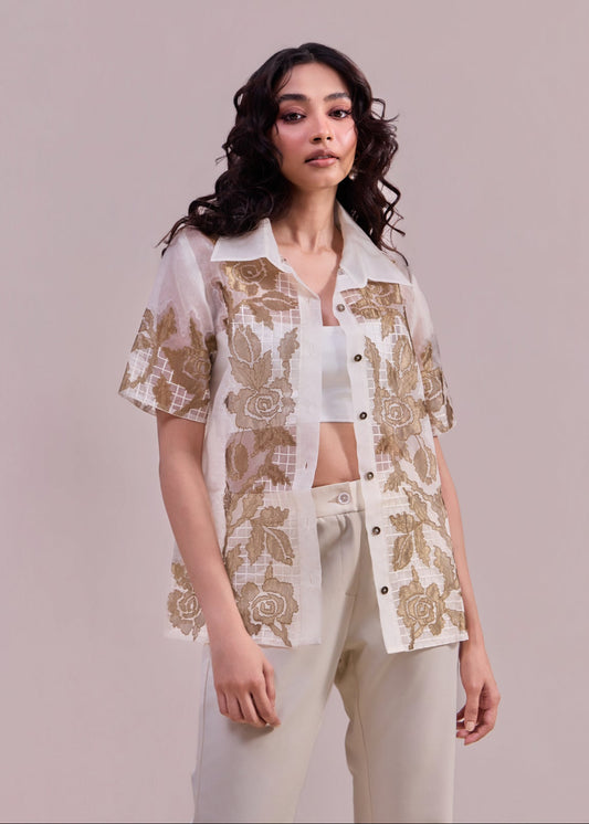 Woman wearing a floral embroidered outfit on a plain background