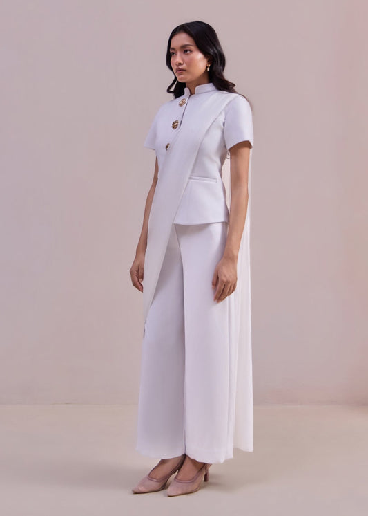 Woman wearing a white outfit against a plain background