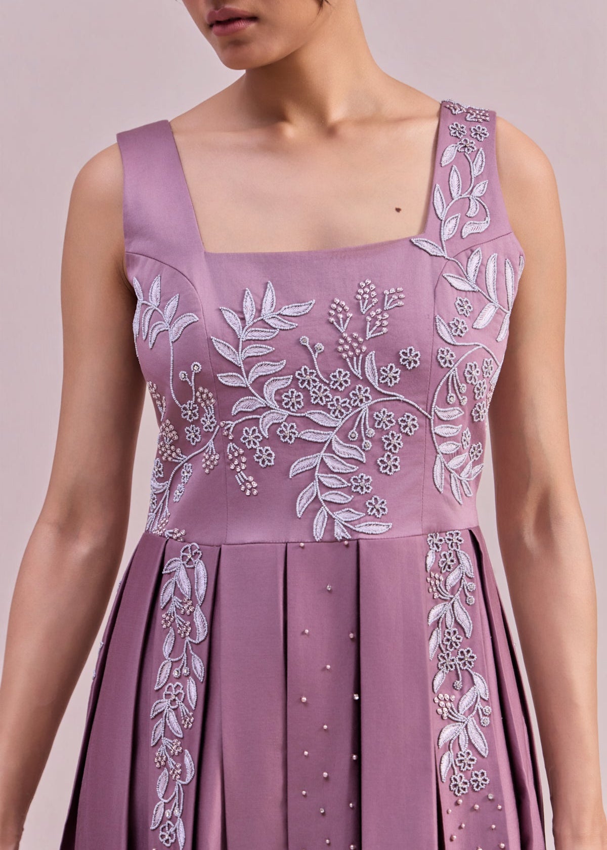 Purple dress with floral embroidery on a plain background