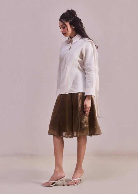 Woman wearing a white shirt and brown skirt on a plain background