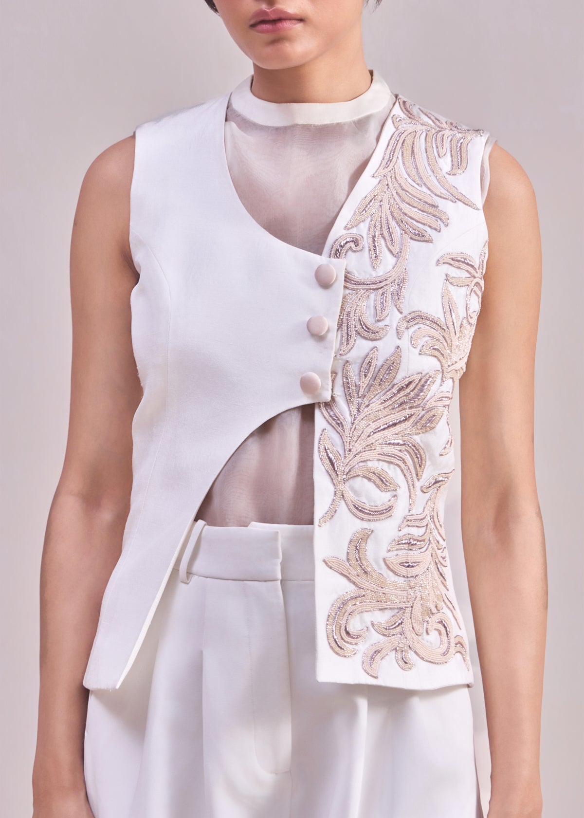 White sleeveless top with floral embroidery on a plain background