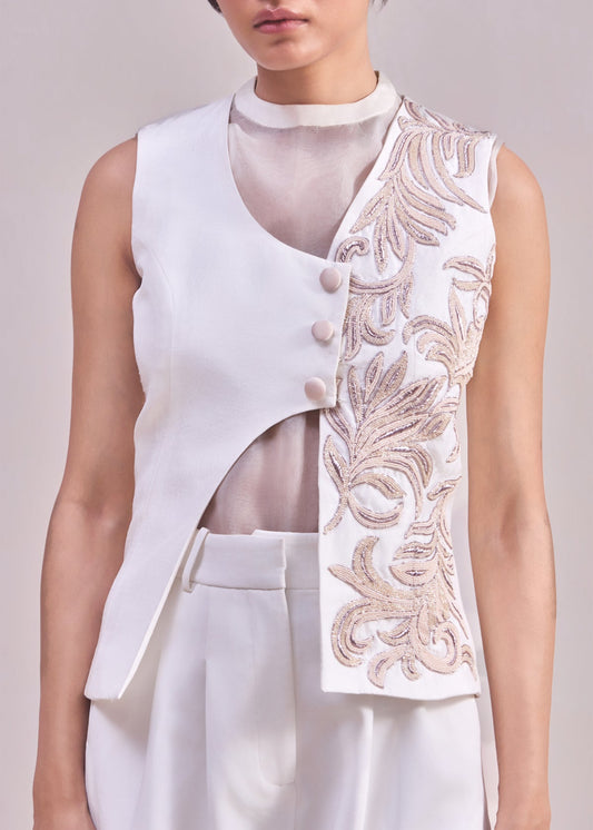 White sleeveless top with floral embroidery on a plain background