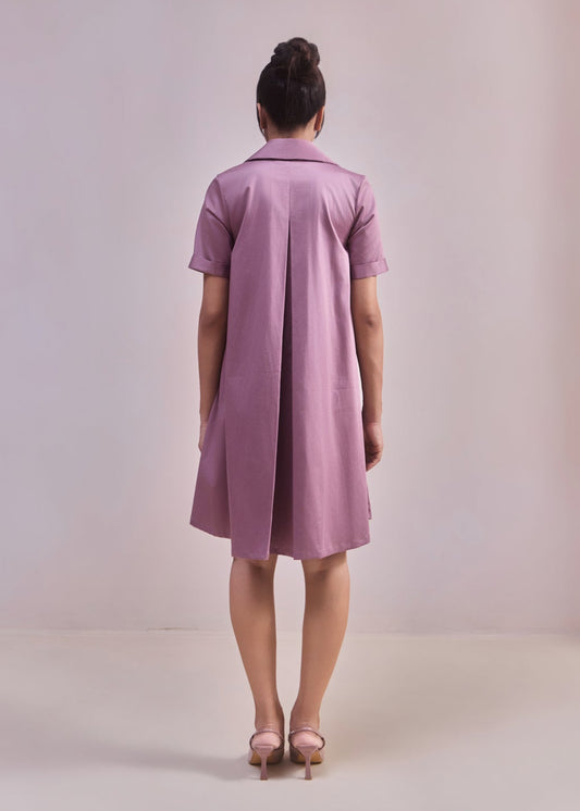 Woman wearing a pink dress against a plain background